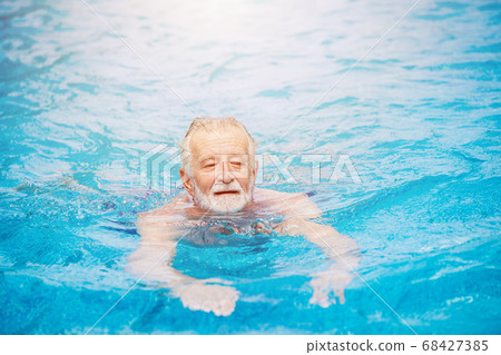 Caucasian healthy elder swimming at the swimming pool Caucasian healthy elder swimming at the swimming pool 68427385