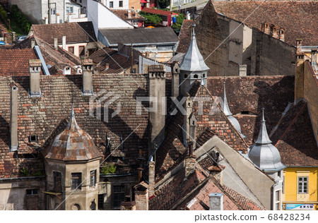 Aerial view on red tiled roofs of medieval Brasov town in Transylvania, Romania. Europe Aerial view on red tiled roofs of medieval Brasov town in Transylvania, Romania. Europe 68428234