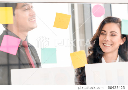 Business people work on project planning board 68428423