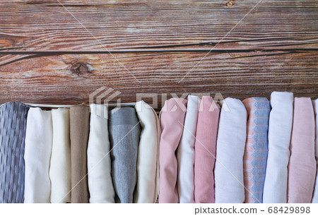 Vertical storage of clothing. Organizer wardrobe boxes with clothes top view on wooden table Vertical storage of clothing. Organizer wardrobe boxes with clothes top view on wooden table 68429898