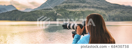 Travel photography professional photographer woman tourist shooting with professional telephoto lens camera on tripod shooting wildlife on Alaska cruise panoramic banner 68430738