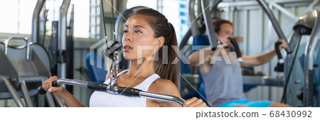 Gym woman working out using fitness machine banner 68430992