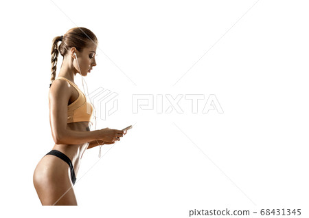 young fitness woman with earphones listens to 68431345