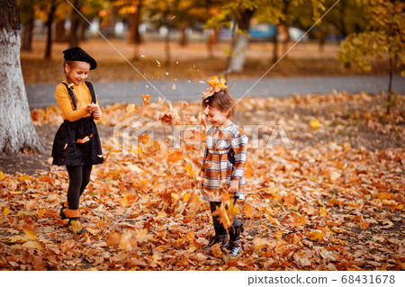 little sisters playing with leaves in autumn Park. little sisters playing with leaves in autumn Park. 68431678