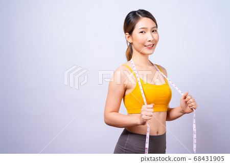 Asian sporty woman measuring her waist by measure tape isolated on white backgroun 68431905