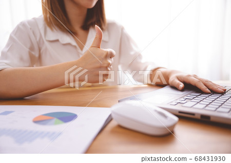 Businessperson working in the office giving thumbs up Businessperson working in the office giving thumbs up 68431930