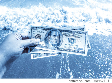 Girl holding a money bill of 300 dollars on background of sea waves Girl holding a money bill of 300 dollars on background of sea waves 68432191