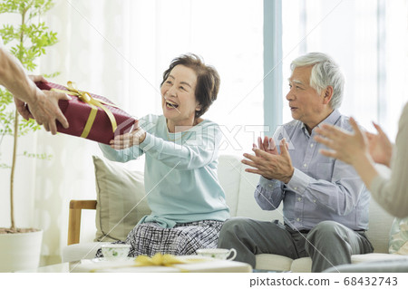 Senior woman receiving a present Senior woman receiving a present 68432743