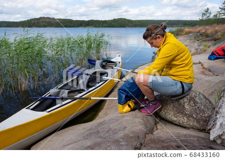 Young caucasian woman resting on riverside after kayaking. Young caucasian woman resting on riverside after kayaking. 68433160
