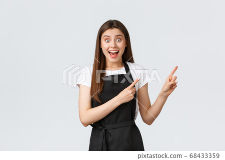 Small business, employees and coffee shop concept. Happy and surprised cafe barista hear amazing news and pointing upper right corner. Impressed grocery store employee react to awesome news Small business, employees and coffee shop concept. Happy and surprised cafe barista hear amazing news and pointing upper right corner. Impressed grocery store employee react to awesome news 68433359