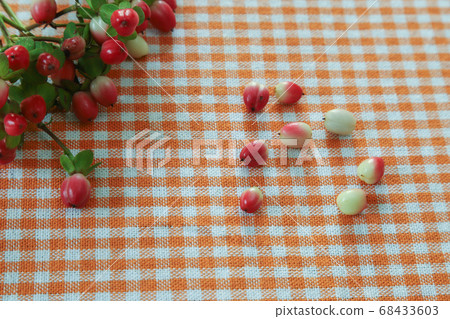 Hypericum fruits placed on a checkered tablecloth 68433603