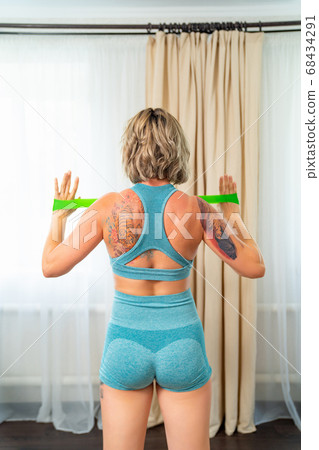 rear view. girl engaged fitness with rubber bands rear view. girl engaged fitness with rubber bands 68434291
