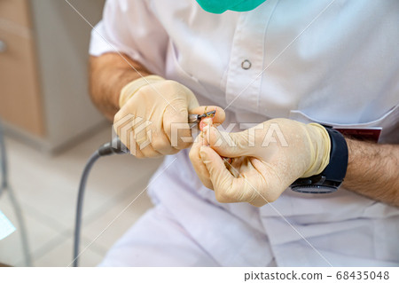 hands dentist adjust the size of the denture. 68435048