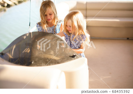 kids girls helm of boat on pier. travel on water. kids girls helm of boat on pier. travel on water. 68435392