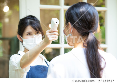 A female clerk who takes the temperature 68435647