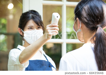 A female clerk who takes the temperature 68435648