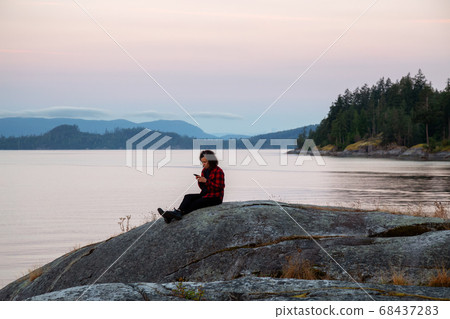 Girl Watching a Peaceful Sunrise on the Ocean Coast Girl Watching a Peaceful Sunrise on the Ocean Coast 68437283