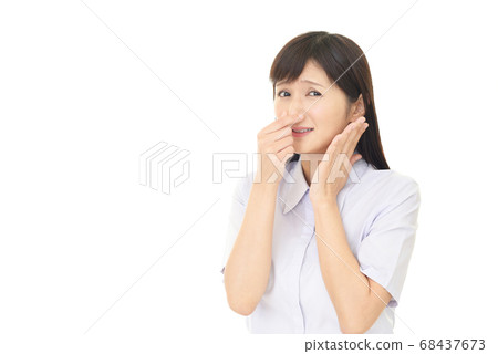 A woman holding a nose 68437673