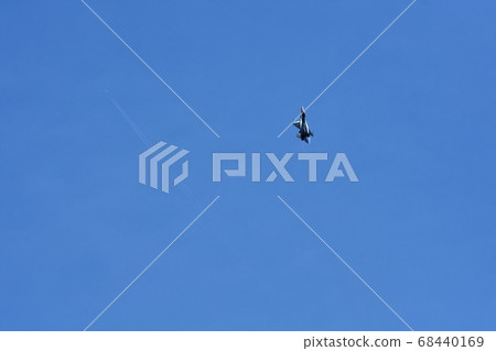 Soaring U.S. Air Force F-16 fighter jets and contrails of civilian aircraft flying far above 68440169