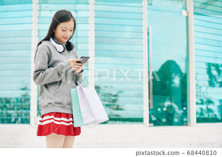 Young Asian woman with shopping bags Young Asian woman with shopping bags 68440810