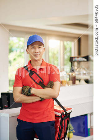 Courier standing in cafe Courier standing in cafe 68440935