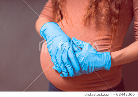 Pregnant Woman in blue gloves against flu and viruses. Healthcare concept. Pregnancy And Infection 68442300