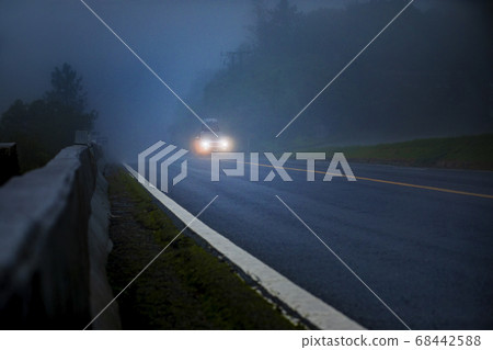 suv car passing on foggy mountain highway in 68442588