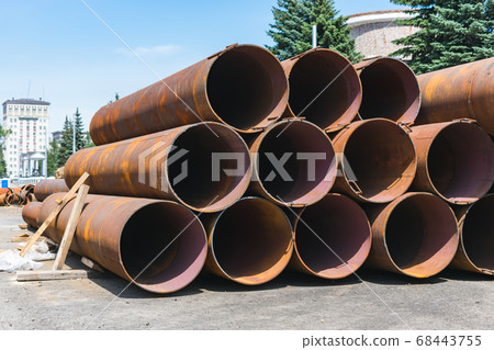 Large, old and rusty sewer pipes stacked in one batch for recycling 68443755