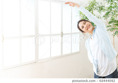 Young woman doing radio exercises indoors 68444092