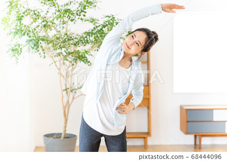 Young woman doing radio exercises indoors Young woman doing radio exercises indoors 68444096