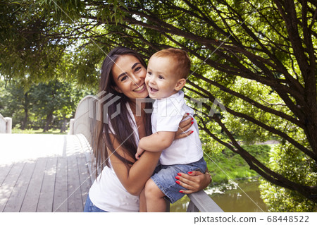 young pretty brunette mother with little cute boy walking in park happy smiling, lifestyle people concept 68448522