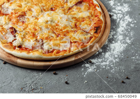 pizza with cheese, sauce and ham, bacon, salami on a gray dark background pizza with cheese, sauce and ham, bacon, salami on a gray dark background 68450049