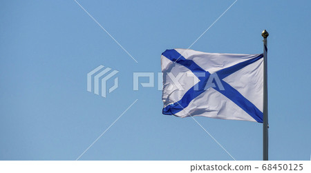 Naval flag of the Russian Navy St. Andrew on a cloudy blue sky background. Russian navy day concept. 68450125