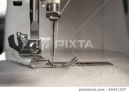 Closeup of sewing machine working part with beige 68451397