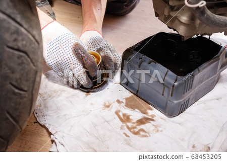 The process of draining oil from a motorcycle The process of draining oil from a motorcycle 68453205