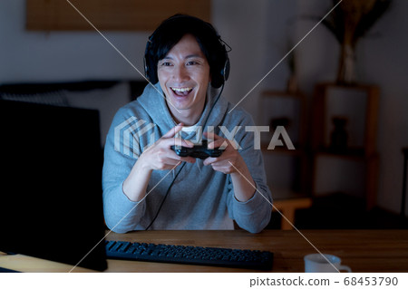 Young men playing online games at midnight 68453790