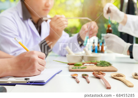 The scientist or doctor make herbal medicine from herb in the laboratory. 68455285