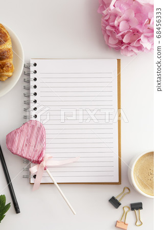 Table top, work space with notebook, cup of coffee and croissant, pink hydrangea. White background. Table top, work space with notebook, cup of coffee and croissant, pink hydrangea. White background. 68456333