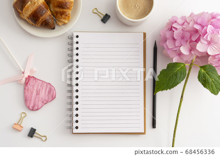 Table top of work space, feminine background. Cup of coffee with pink hydrangea and notebooks. 68456336