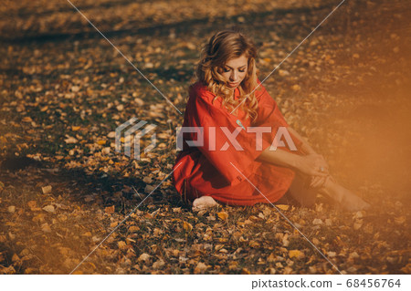 beautiful girl in a red dress in the autumn forest. nature walk. getting energy from the sun, trees. fairitale scene of a woman laying in the forest beautiful girl in a red dress in the autumn forest. nature walk. getting energy from the sun, trees. fairitale scene of a woman laying in the forest 68456764
