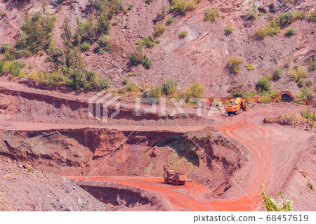 Huge iron ore quarry with working dump trucks Huge iron ore quarry with working dump trucks 68457619