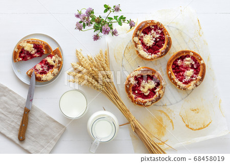 White table with yeasty sweet pastry with fresh currants and raspberries and streusel topping. 68458019