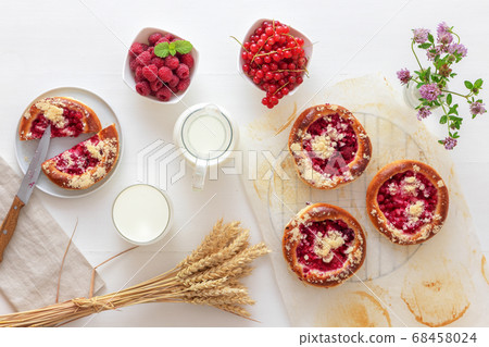 White table with yeasty sweet pastry with fresh currants and raspberries and streusel topping. 68458024