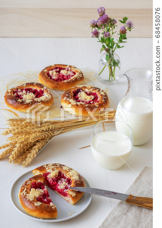 White table with yeast sweet pastry with fresh currants and raspberries and streusel topping. White table with yeast sweet pastry with fresh currants and raspberries and streusel topping. 68458076