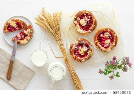 White table with yeast sweet pastry with fresh currants and raspberries and streusel topping. 68458078