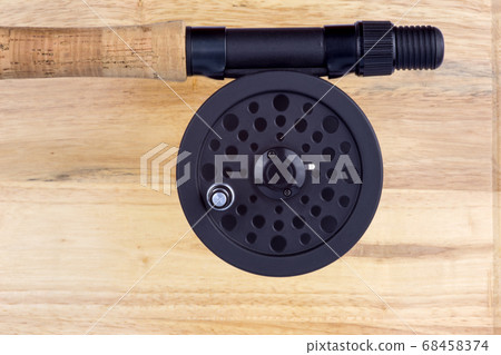 Fly Rod Handle and Reel on Wooden Background Fly Rod Handle and Reel on Wooden Background 68458374