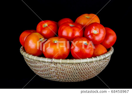 Tomatoes in a Rattan Bowl on a Black Background Tomatoes in a Rattan Bowl on a Black Background 68458967