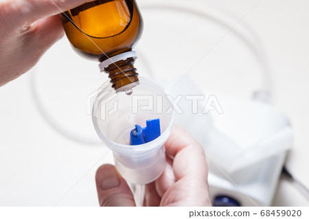 dripping medicine from glass bottle into nebulizer dripping medicine from glass bottle into nebulizer 68459020