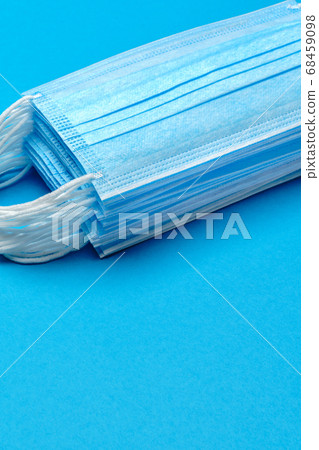 Stack of Disposable blue medical face masks on blue background Stack of Disposable blue medical face masks on blue background 68459098