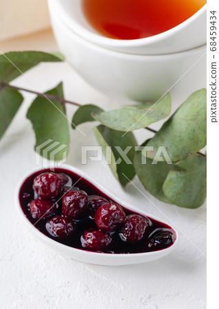 cherry jam in a white sauce pot and a mug of tea cherry jam in a white sauce pot and a mug of tea 68459434